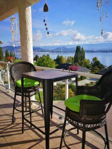 a table and chairs on a porch with a view of the water at Lakeview Oasis Bed and Breakfast in West Kelowna
