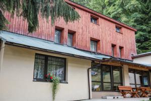 een rood gebouw met ramen en bloemen erop bij Chata Bajama in Bedřichov