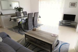 uma sala de estar com um sofá e uma mesa em Partilha Sol Apartment em Alvor