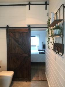 a bathroom with a sliding barn door and a bed at The Retreat in Nicholls Rivulet