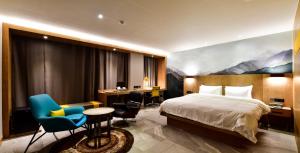 una camera d'albergo con letto e scrivania di Hotel Ritz a Suwon