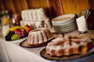 una mesa cubierta con platos de comida y postres en Chata Bajama en Bedřichov