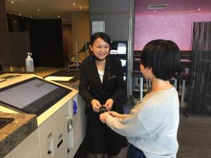 a woman is standing next to a woman at a counter at Hotel Villa Fontaine Tokyo-Kudanshita in Tokyo