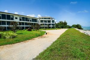 a building on the beach next to a dirt road at The Beach Resort & Residence - SHA Plus in Pathiu