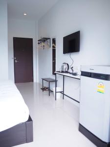a room with a refrigerator and a table with a tv at Kangsadan Resort in Loei