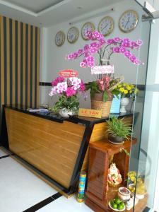 een kamer met klokken aan de muur en bloemen bij Phuc Hau Hotel in Con Dao