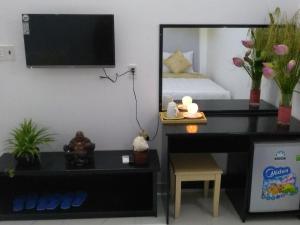 een kamer met een bureau, een spiegel en een bed bij Phuc Hau Hotel in Con Dao