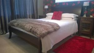1 dormitorio con 1 cama con manta de piel y almohadas en Korbaylen Estate, en Hamilton