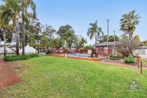 a park with a pool and palm trees at Central Caravan Park in Perth