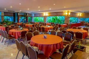 a banquet hall with orange tables and chairs at Hatyai Paradise Hotel & Resort in Hat Yai