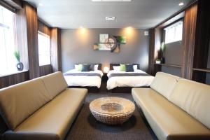 ein Wohnzimmer mit 2 Betten und einem Sofa in der Unterkunft Tanimachi 4chome 4F in Osaka