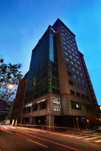 een hoog gebouw op de hoek van een straat bij The Tango Hotel Taipei ChangAn in Taipei