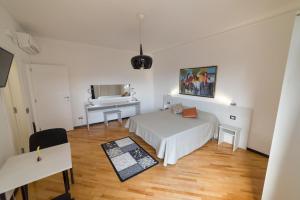 a white bedroom with a bed and a piano at Opera House in Palermo
