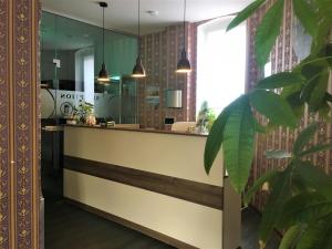 a lobby with a reception counter and a plant at Pension Am Pollingpark in Dessau