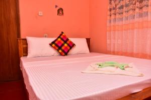 a bedroom with a bed with two towels on it at Our House Hikkaduwa in Hikkaduwa