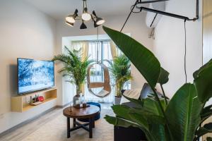 a living room with potted plants and a tv at Chongqing Jiangbei·Guanyinqiao· Locals Apartment 00139090 in Chongqing