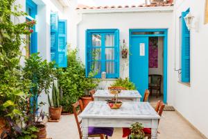 um pátio com persianas azuis, uma mesa e cadeiras em Cypriot Swallow Boutique Hotel em Lefkosa Turk