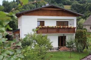 a white house with a balcony with flowers on it at Marko Apartmány in Oščadnica