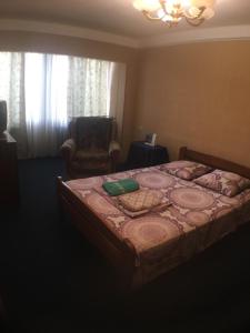 a bedroom with a large bed and a chair at Apartment on Peremohy Ave 17 in Kyiv