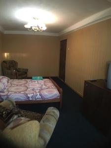 キーウにあるApartment on Peremohy Ave 17のベッド、ソファ、テレビが備わる客室です。