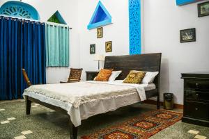a bedroom with a bed and blue curtains at Kings Retreat Jodhpur in Jodhpur