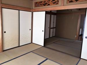 um quarto vazio com portas de vidro e pisos de azulejo em Guesthouse LARGO em Odawara