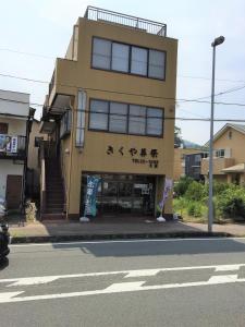 un edificio amarillo con escritura en el costado en Guesthouse LARGO, en Odawara