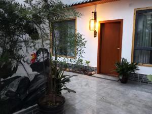 a house with plants in front of a door at Zhangjiajie Tingyutang Little Yard in Zhangjiajie