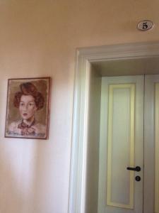 Alloggio della Villetta في بالاتسولو سول أوليو: لوحة لفتاة على جدار بجانب باب