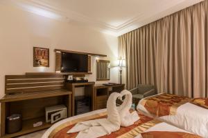 a hotel room with a bed and a television at Petra Moon Hotel in Wadi Musa