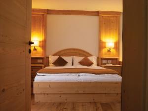 a bedroom with a large bed with a wooden headboard at Garni Le Maddalene in Coredo