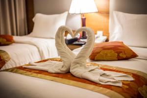 two swans towels on a bed in a hotel room at Petra Moon Hotel in Wadi Musa