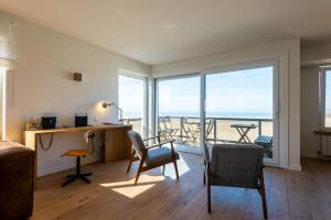a bedroom with a desk and a view of the ocean at Seaview Zeebrugge in Zeebrugge