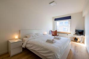 ゼーブルッヘにあるSeaview Zeebruggeの白いベッドルーム(ベッド1台、テレビ付)