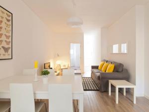 リスボンにあるシティ ステイズ プリンチペ レアル アパートメンツの白いリビングルーム(ソファ、テーブル付)
