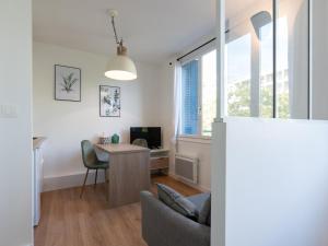 a living room with a table and a chair at Appartements Le Berliet - Montplaisir in Lyon