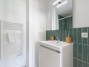 a white bathroom with a sink and a mirror at Appartements Le Berliet - Montplaisir in Lyon +24 photos