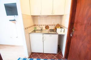 a small kitchen with white cabinets and a sink at Apartments Milena in Tivat