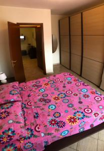 ラティーナにあるCasa MALÙのベッドルームに花が飾られたピンクベッド1台