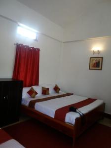 a bedroom with two beds and a red curtain at Heritage Lodge in Cherrapunji