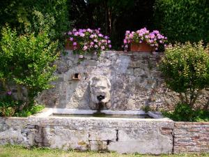 a stone wall with a statue of a dog on it at Fattoria Gambaro di Petrognano in Collodi
