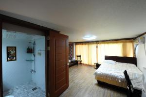 a bedroom with a bed and a bathroom with a shower at Hi Hotel in Ulsan