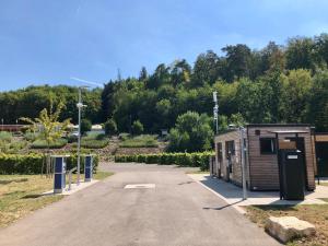 a parking lot with a small building in a garden at Campinghütte im SportErlebnisPark Allmersbach im Tal in Allmersbach im Tal