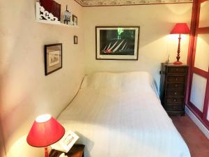 a bedroom with a white bed and a red lamp at XAVIER 62 Maison Familiale 4 Chambres au Calme in Pyla-sur-Mer
