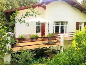 a house with a wooden deck with an umbrella at XAVIER 62 Maison Familiale 4 Chambres au Calme in Pyla-sur-Mer