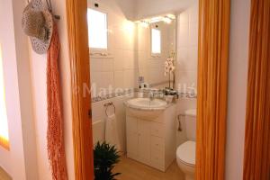 a bathroom with a white toilet and a sink at Casa Calma in Son Serra de Marina