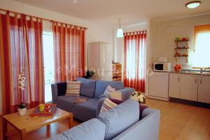 a living room with a blue couch and a table at Casa Calma in Son Serra de Marina +35 photos