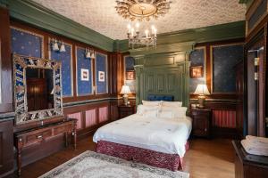 um quarto com uma cama, um espelho e um lustre em The Old England Manor em Ren'ai