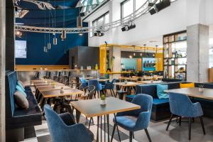 un restaurante con mesas de madera y sillas azules en D8 Hotel, en Budapest