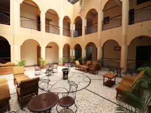 a courtyard with tables and chairs in a building at Hotel Buddha in Varanasi